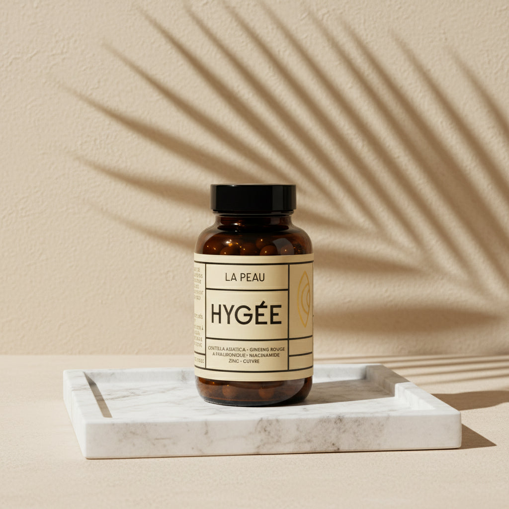 An amber glass bottle of Allnord’s HYGÉE La Peau skin supplement stands on a white marble tray against a sand‑beige wall, with palm‑leaf shadows sweeping across the scene. A warm, sunlit still life with clean lines and editorial minimalism.