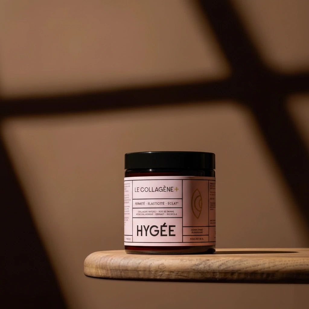 A stylish product shot of the HYGÉE Le Collagène+ jar sitting on a wooden surface with artistic, soft shadows in the background.