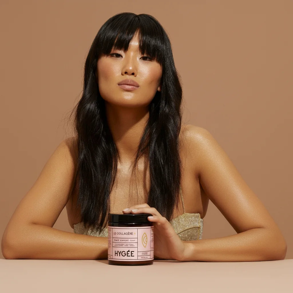 Model with long dark hair presenting a jar of HYGÉE Le Collagène+ marine collagen supplement against a neutral background.